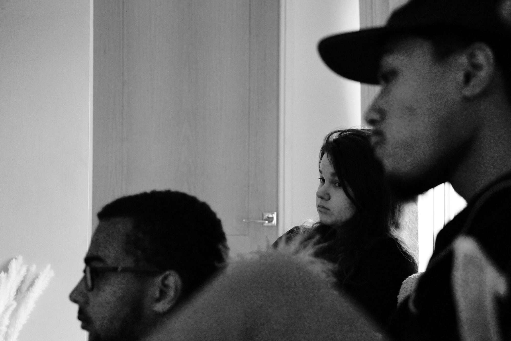 A candid, unguarded moment between people, made in soft black and white.